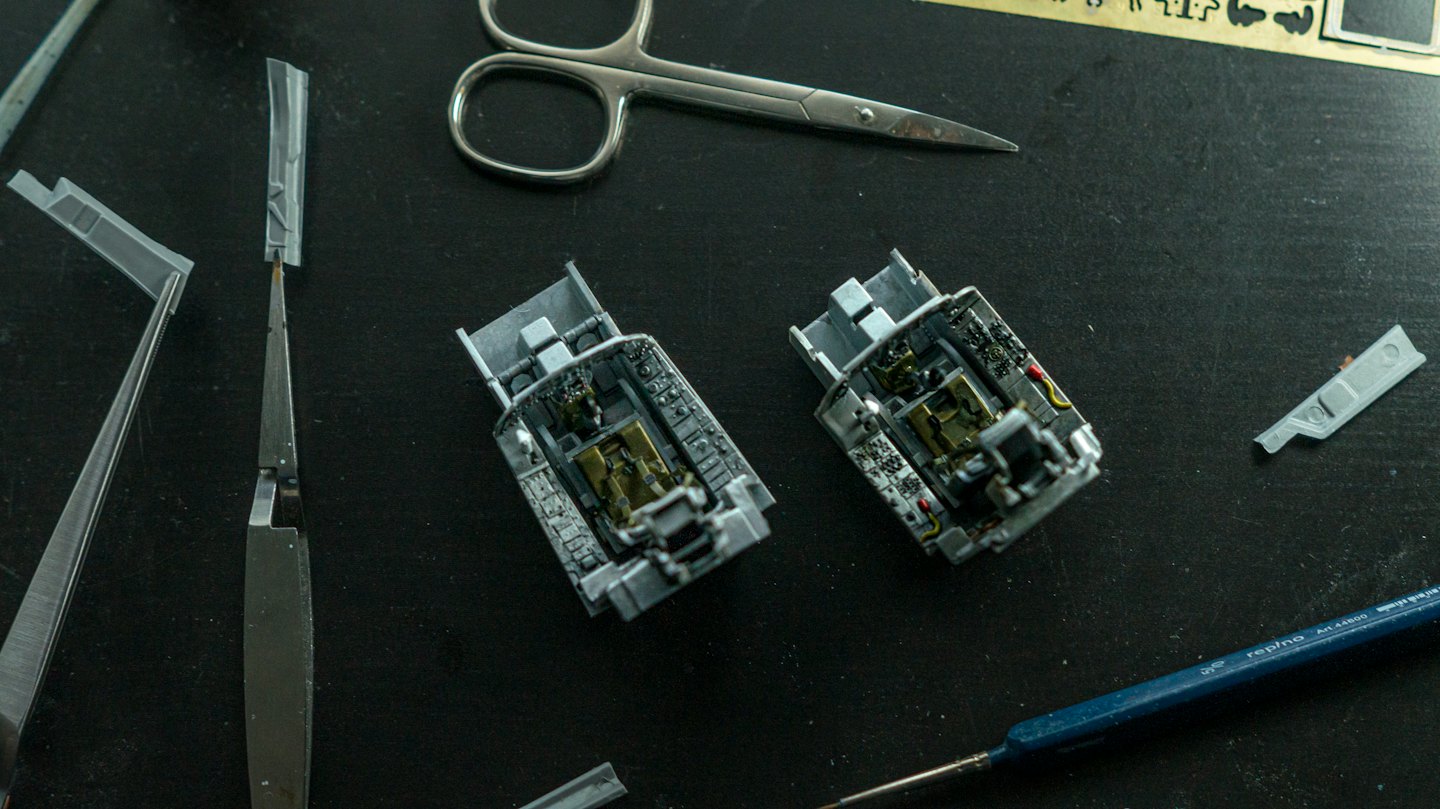Części modeli samolotów i miniaturowe narzędzia ułożone na stole.